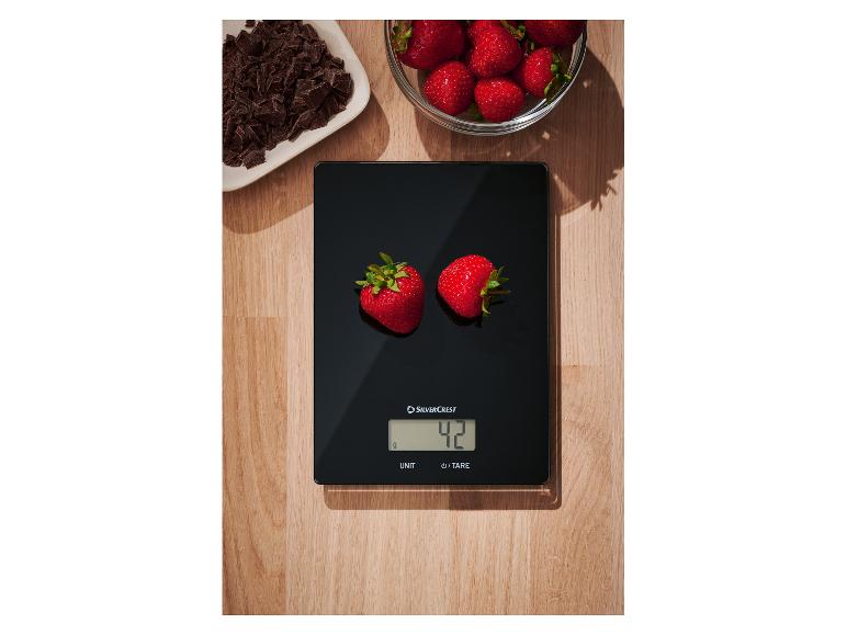 SilverCrest keukenweegschaal weegt twee aardbeien, met chocolade en meer aardbeien ernaast.