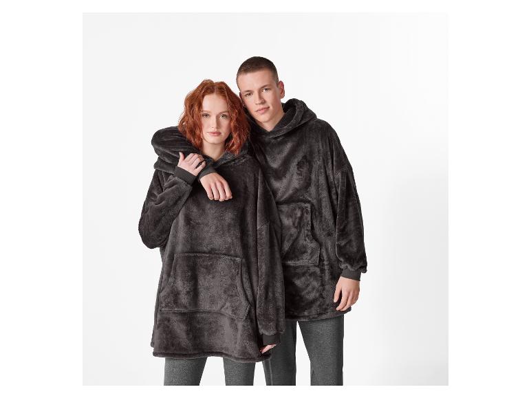 Paar in donkergrijze, pluizige hoodies en joggingbroeken.