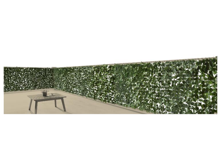 Kunsthaag van bladeren met buitentafel en vaas op een terras.