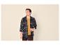 Man in blauw en bruin geruit overhemd, mosterdkleurig T-shirt en bruine corduroy broek.