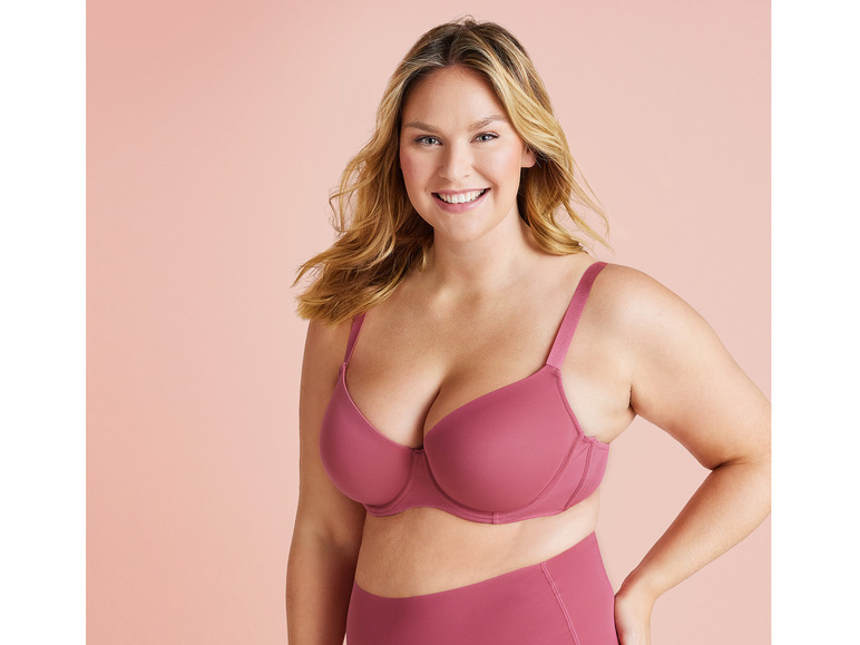 Een vrouw draagt een roze bh en slipje.