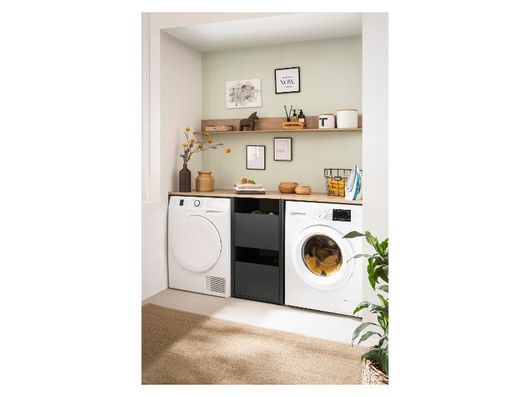 Wasmachine en droger ingebouwd in een moderne wasruimte met houten planken.