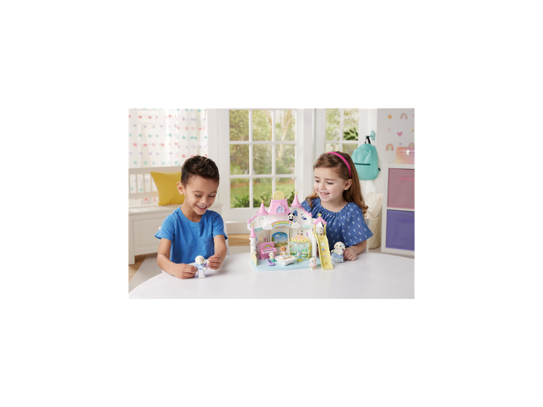 Twee kinderen spelen met een speelset met dieren, met een kasteel en glijbaan.