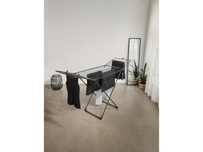 Zwart wasrek met donkere kleding in een lichte kamer.