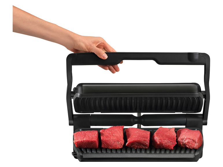 Een zwarte grill met een handvat, met daarop gegrild vlees.