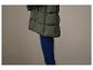 Een groene gewatteerde jas en blauwe jeans.