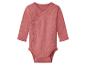 Een roze babyromper met lange mouwen en overslagsluiting.