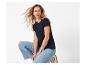Vrouw met wapperend haar, draagt een marineblauw T-shirt en blauwe jeans