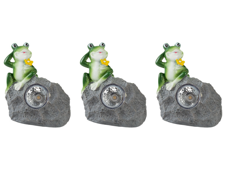 Drie groene kikker-zonnelampjes op stenen