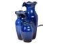 Blauwe keramische binnenfontein met drie vazen en stromend water.