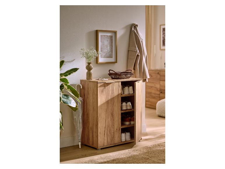 Lichte houten schoenenkast met open deur, schoenen tonend, in een gezellige hal.