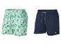 Twee heren zwemshorts: één met citroenprint en één donkerblauw.