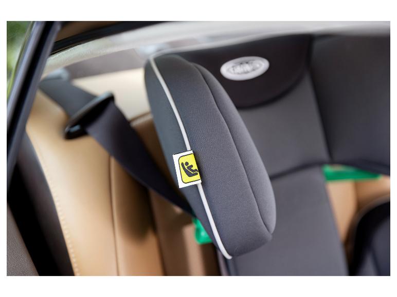 Kinderautostoel met veiligheidsgordel en beige bekleding.