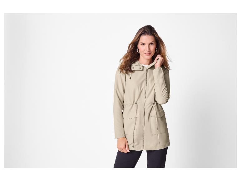 Vrouw draagt een beige parka met capuchon en trekkoord
