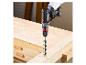 Accuboormachine boort een gat in een houten plank op een werkbank.