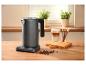 Waterkoker met temperatuurregeling, latte macchiato en chocoladesticks op een houten aanrecht.