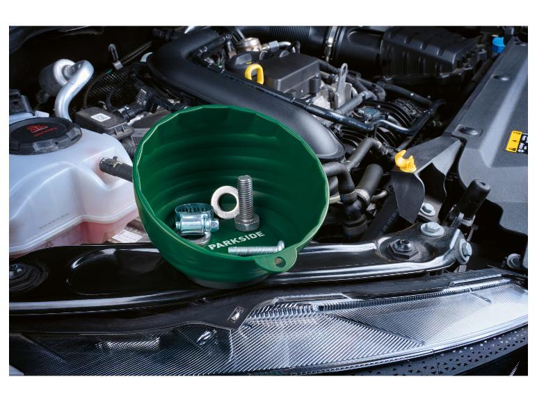 Groene magnetische kom met bouten en klem in een motorruimte.