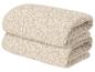Twee gevouwen beige handdoeken met patroon