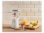 Een blender gevuld met bessen en yoghurt, naast een glas smoothie en vers fruit.