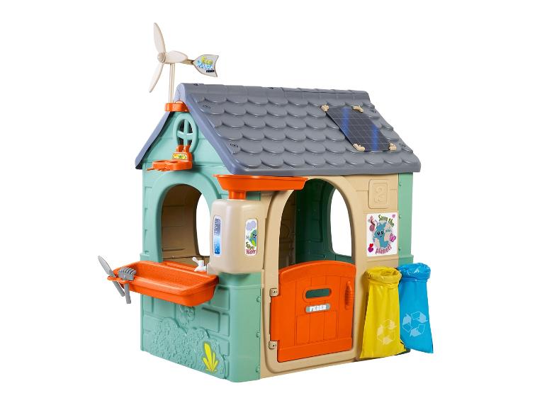 Een plastic speelhuis met een windmolen, zonnepanelen, een wastafel en vuilnisbakken.