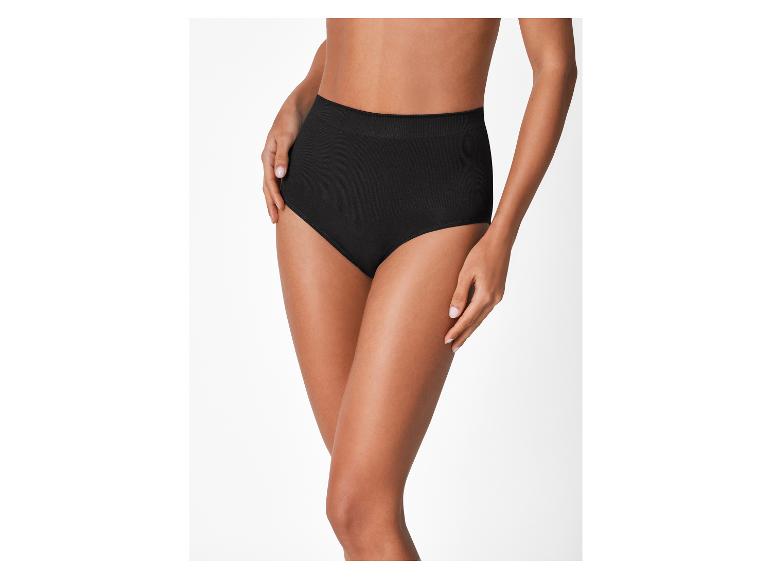 Vrouw in een zwarte, geribbelde slip met hoge taille op een witte achtergrond.