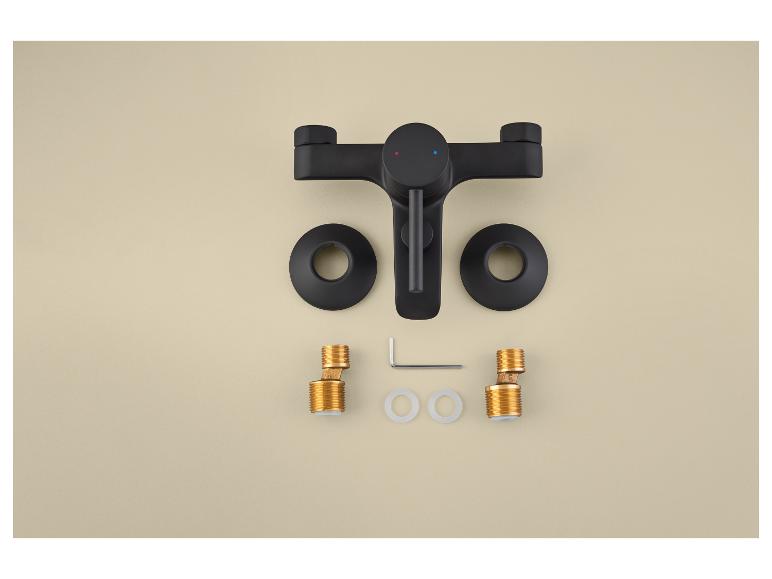 Zwarte badkamerkraan met montageaccessoires op een beige achtergrond