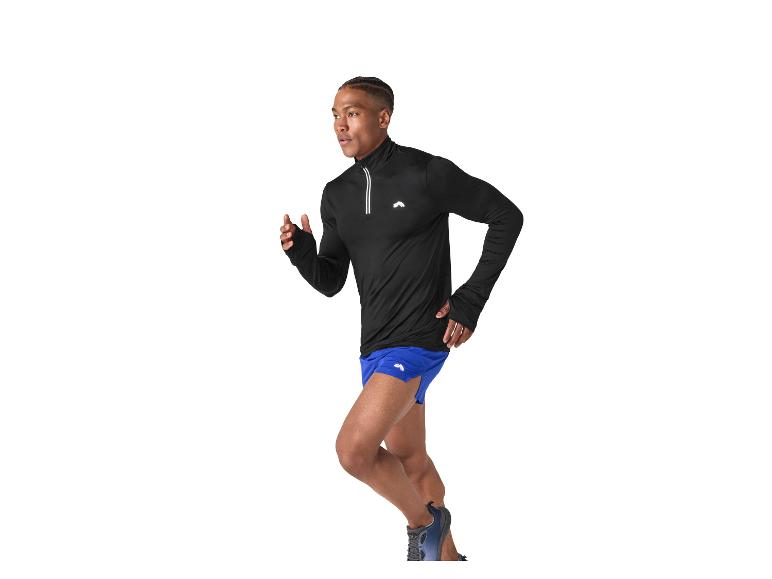 Man rent in zwart sportshirt met lange mouwen en blauwe korte broek.