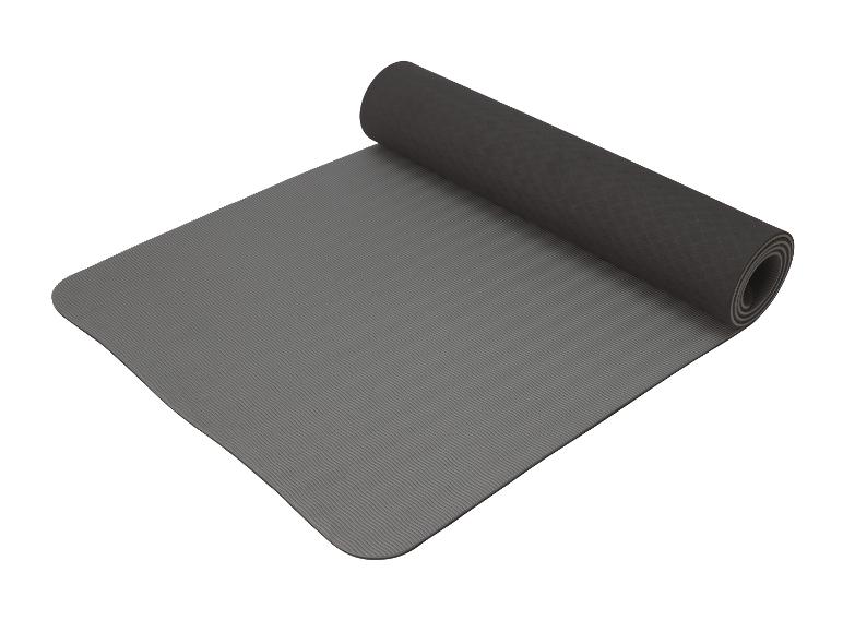 Een grijs yoga matje, opgerold.