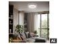 Plafondventilator met licht in een moderne woonkamer met bank en planten.
