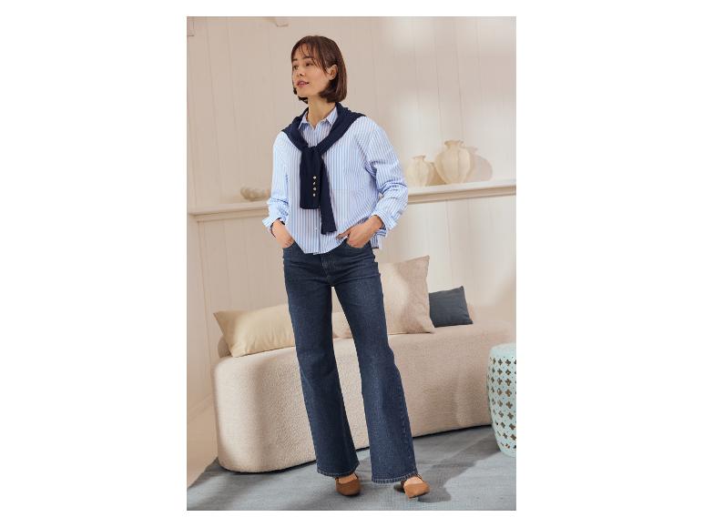 Vrouw in ESMARA wide leg jeans, gestreept overhemd en bruine schoenen.