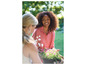 Twee vrouwen in de tuin met roze bloemen