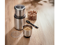 Elektrische koffiemolen met gemalen en hele hazelnoten op een houten tafel