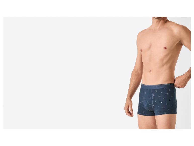 Man draagt donkerblauwe boxershorts met een subtiel geometrisch patroon.