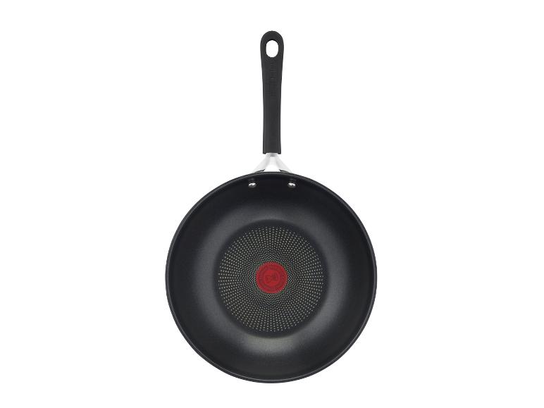 Zwarte wokpan met handvat en rode temperatuurindicator in het midden.