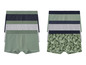 Twee pakjes boxershorts, één met groene bladeren en één effen groen.