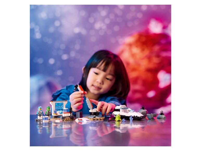 Een kind speelt met LEGO City: Space, inclusief een ruimteschip en een ruimtebasis.