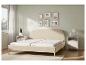 Beige bedframe met een wit matras in een moderne slaapkamer.