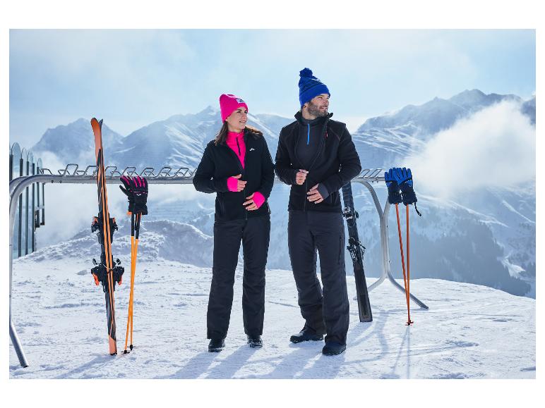 Een man en een vrouw op een besneeuwde berg, dragend Crivit functionele shirts en skikleding.