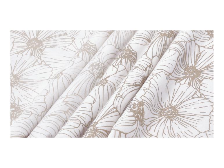 Witte stof met beige bloemenpatroon, gedrapeerd in plooien.