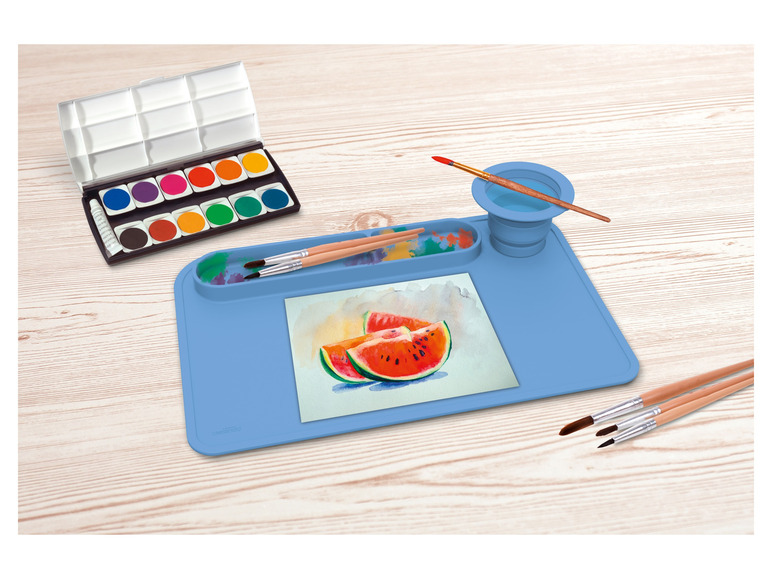 Waterverfset, kwasten en een blauwe siliconen onderlegger voor het schilderen.