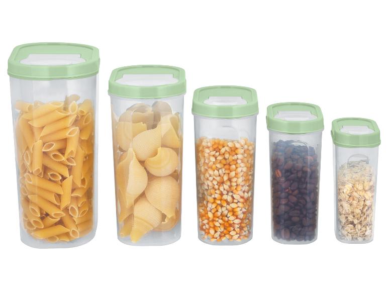 Vijf doorzichtige containers met groene deksels, gevuld met pasta, maïs, koffie en haver.