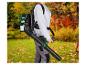 Persoon met bladblazer op de rug in een tuin met herfstbladeren.