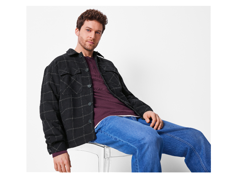 Mannelijk model in een zwart flanellen overhemd en jeans.