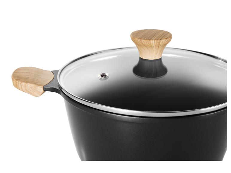 Zwarte pan met glazen deksel en houten handgrepen.