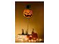Halloween pompoendecoratie met hoge hoed, gloeiende ogen en lichtslingers.