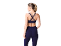 Vrouw van achteren in een donkerblauwe sportbeha en bijpassende legging.