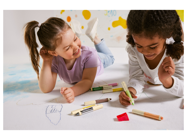 Kinderen tekenen met pastelkrijtjes.