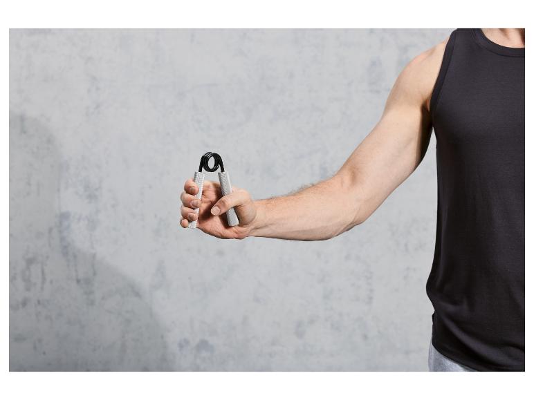 Een man in een zwart tanktop gebruikt een handgreep voor oefeningen.