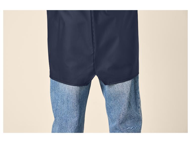 Onderkant van een donkerblauwe regenjas over een blauwe spijkerbroek.