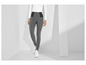 Een model draagt ​​grijze leggings met witte sneakers.